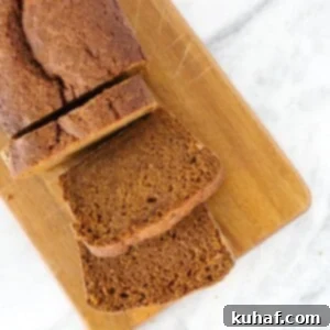 pumpkin bread slices wooden board on marble counter.