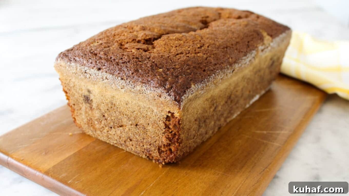 pumpkin bread loaf unsliced on wooden board.