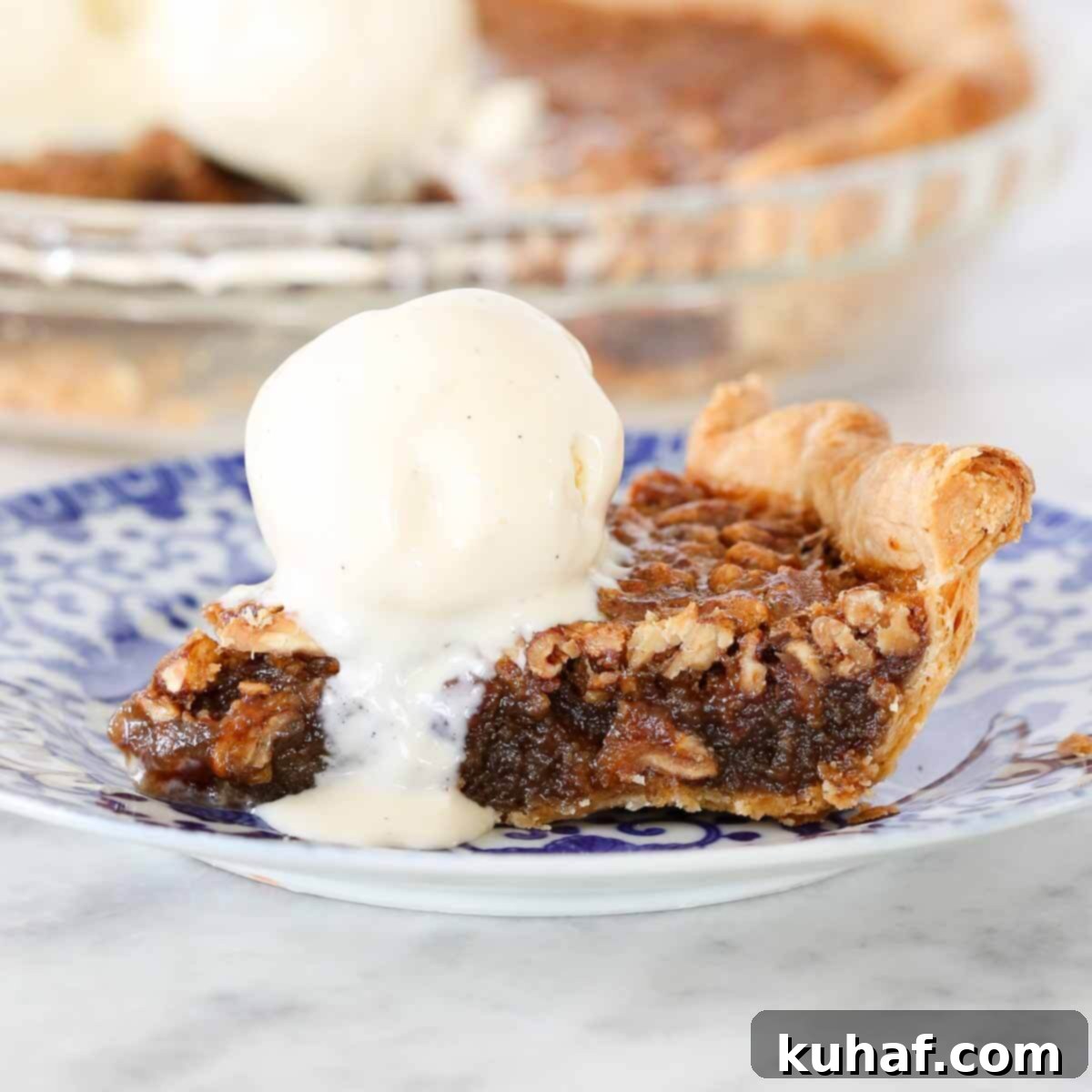 slice of bourbon pecan pie with ice cream scoop.