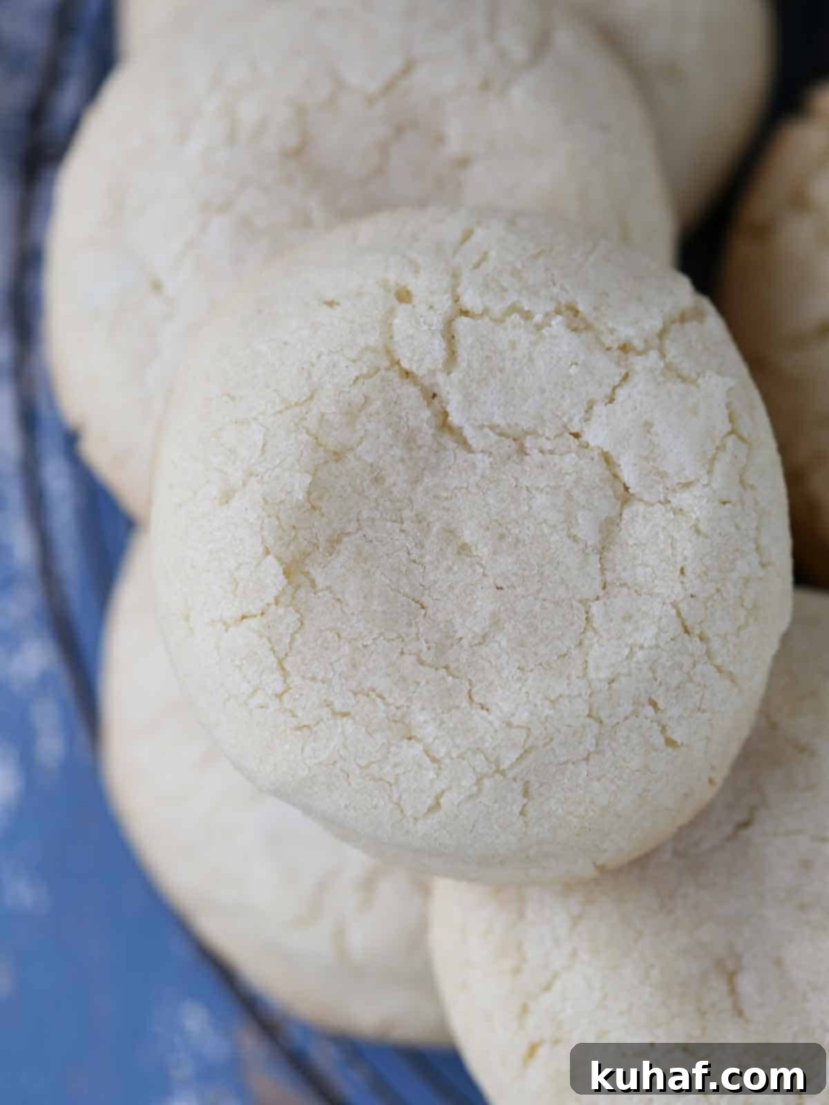 whole sugar cookies piled high on rack.