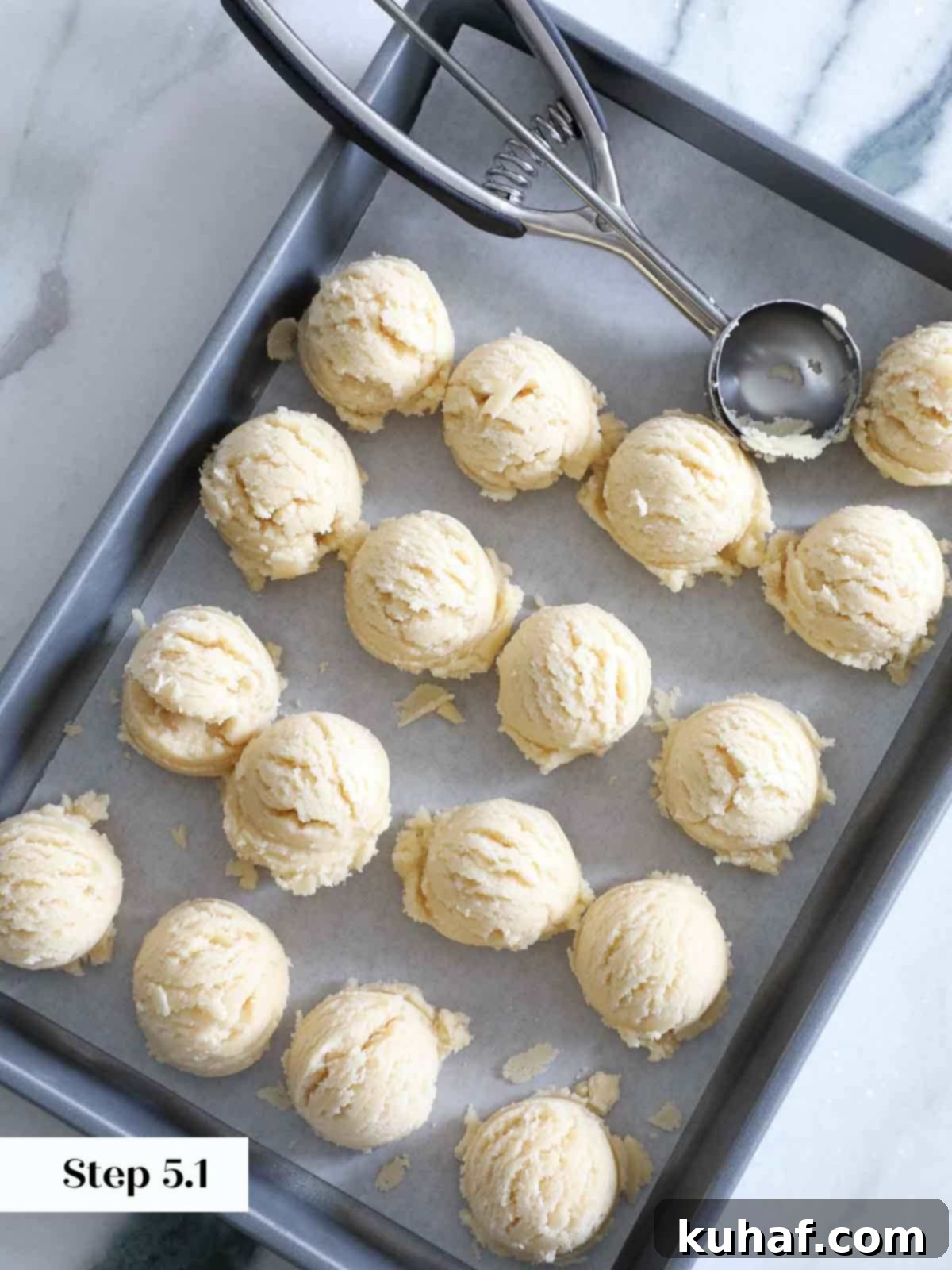 scooping sugar cookie dough on baking sheet.