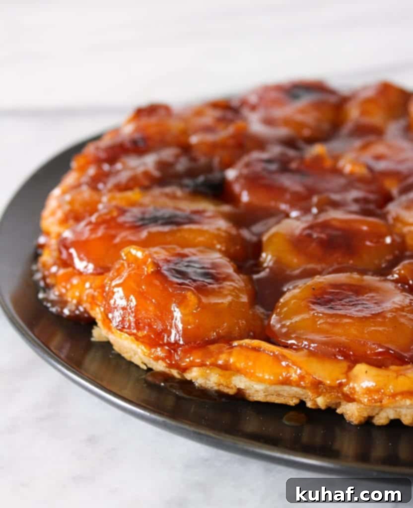 Close-up of a rustic Apple Tarte Tatin, showcasing its buttery puff pastry and deeply caramelized apple slices.