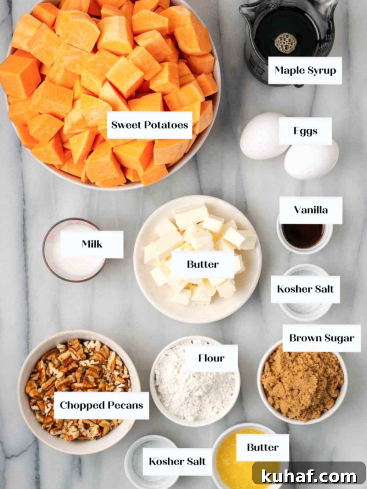 Decadent Sweet Potato Casserole with Crunchy Pecans 4 A flat lay of fresh sweet potatoes, maple syrup, eggs, butter, and other ingredients for the casserole on a marble surface.