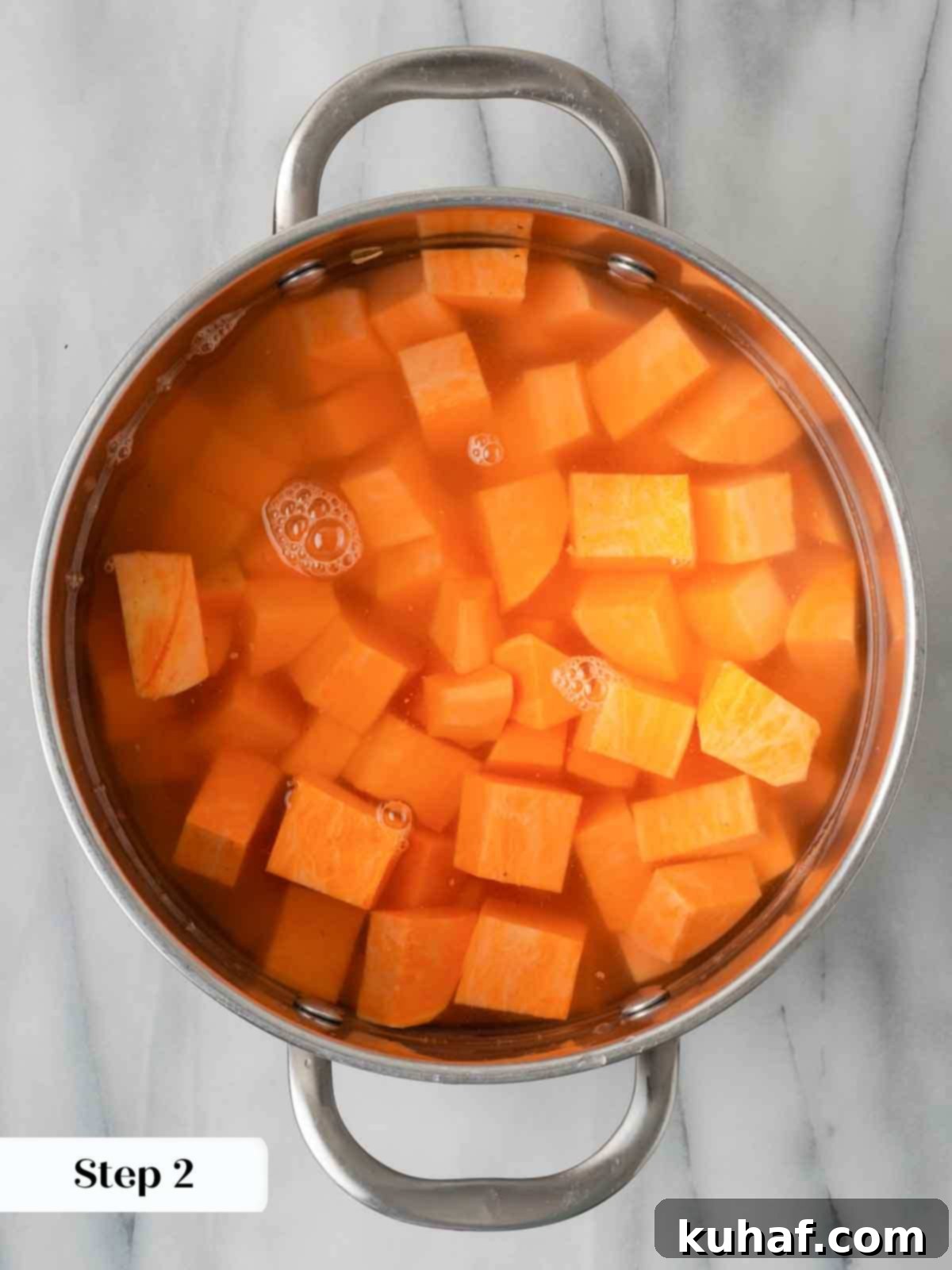 Decadent Sweet Potato Casserole with Crunchy Pecans 5 Sweet potatoes boiling in water in a large pot on the stove.