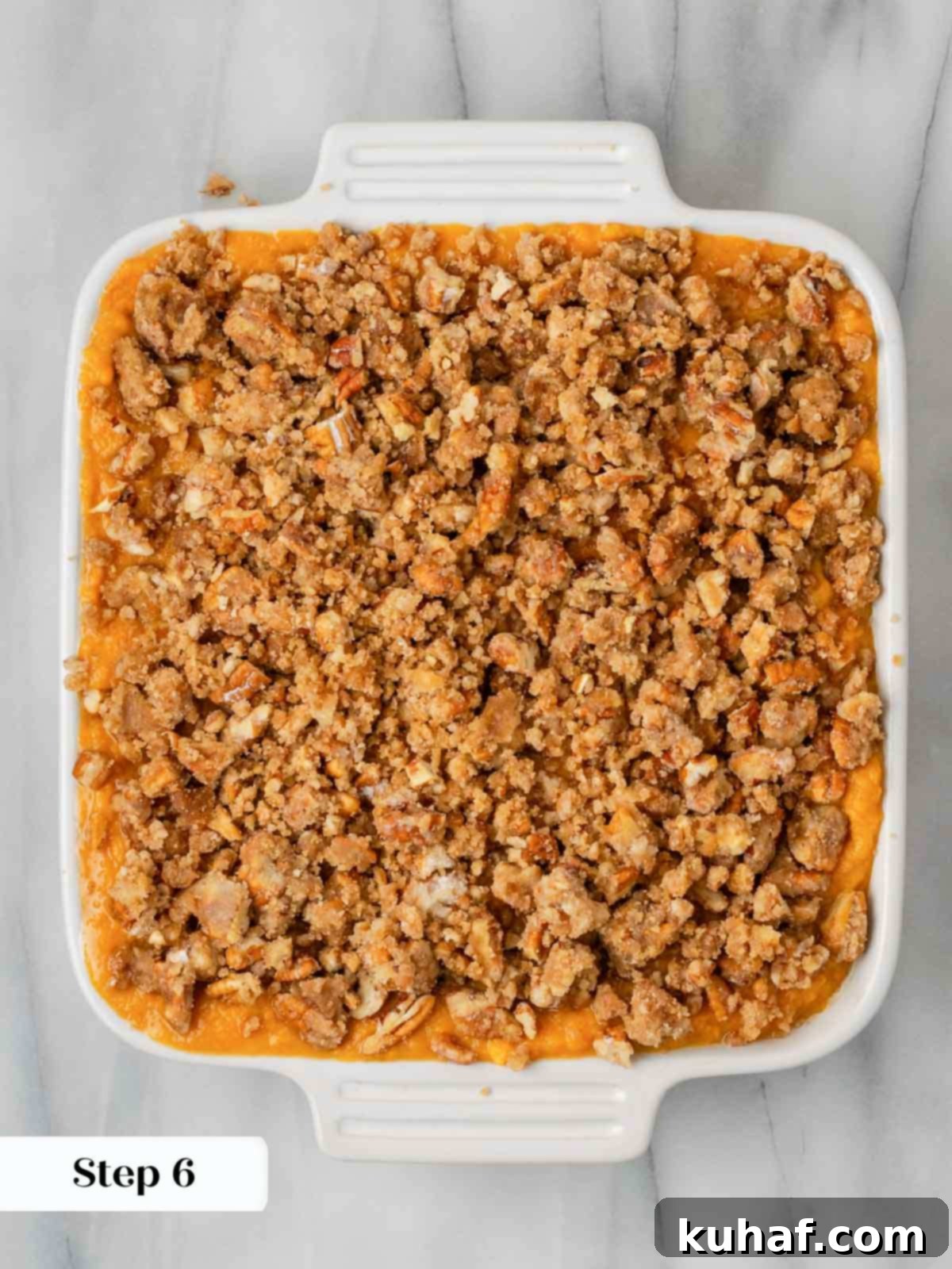 Decadent Sweet Potato Casserole with Crunchy Pecans 9 Unbaked sweet potato casserole in a white baking dish, with the pecan topping sprinkled over.