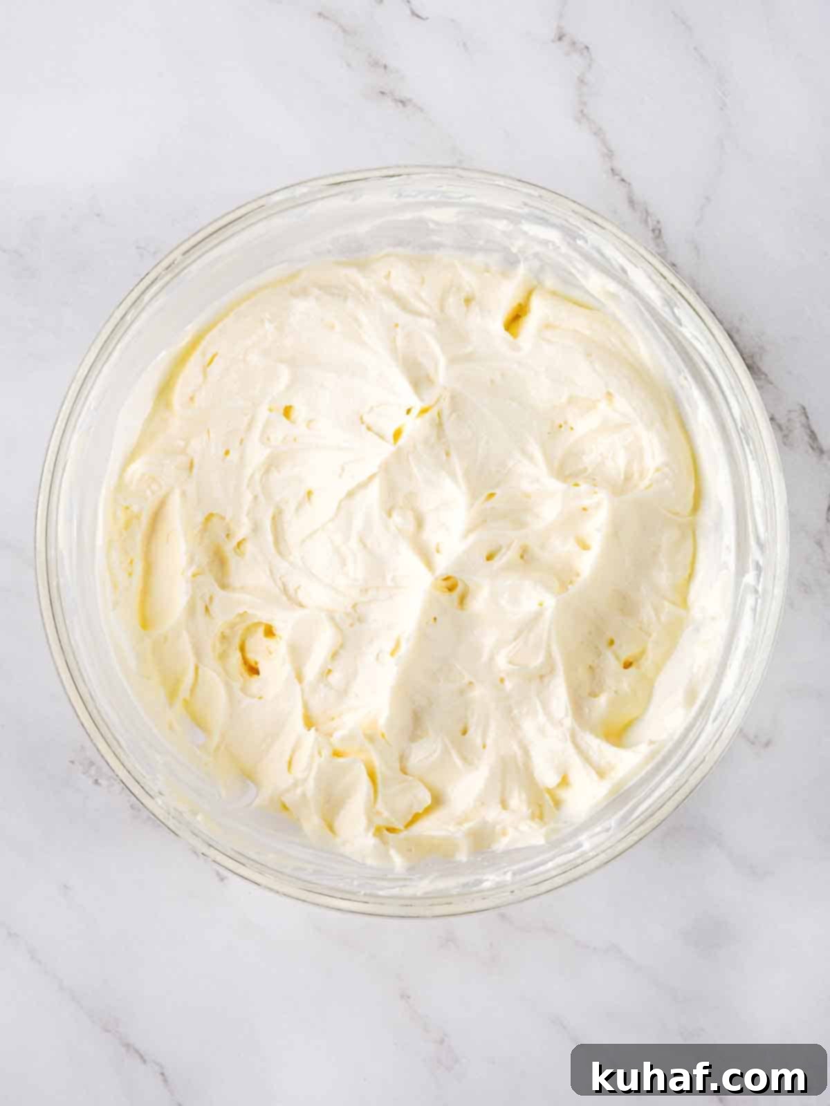 fluffy cream cheese frosting in clear bowl.