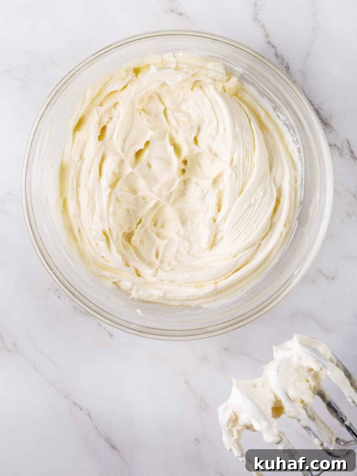 cream cheese buttercream frosting in bowl with beaters.