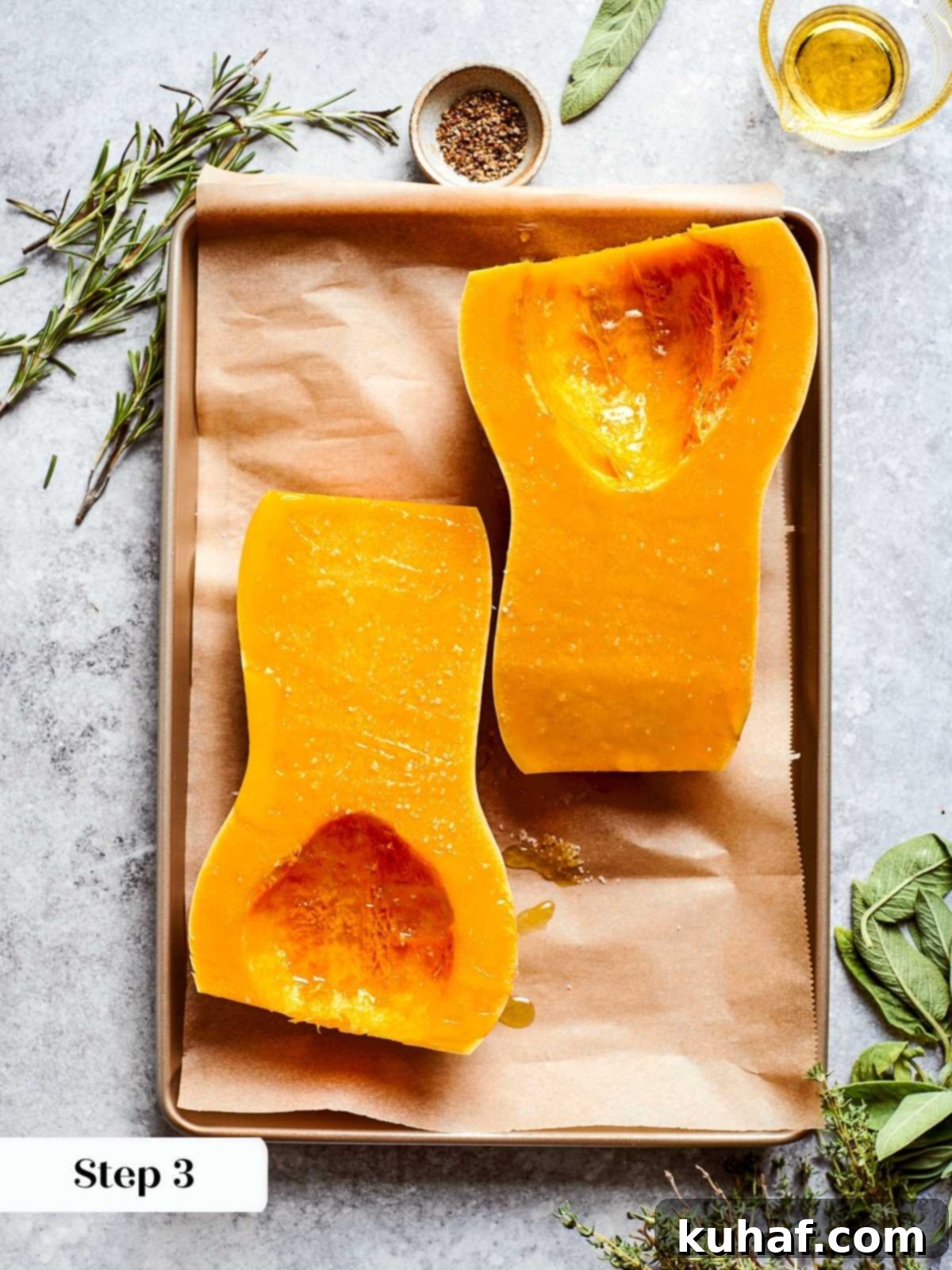 Butternut squash cut in half with seeds scooped out, prepped for roasting.