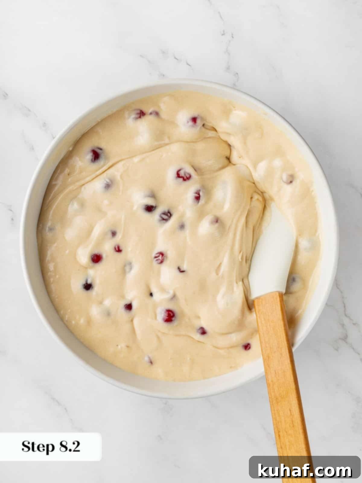 Thick cranberry cake batter resting in bowl showing creamy texture before baking.