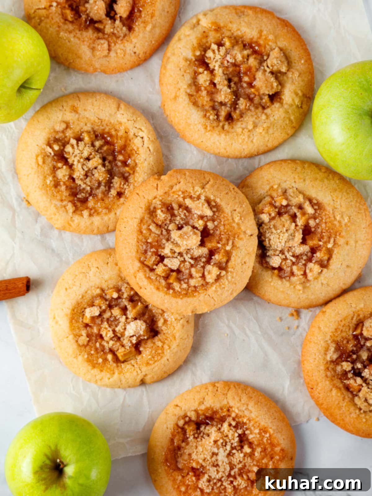 An inviting spread of assorted apple pie cookies on a rustic wooden table, showcasing their golden crumble tops, soft chewy centers, and varied textures, ready to be enjoyed.