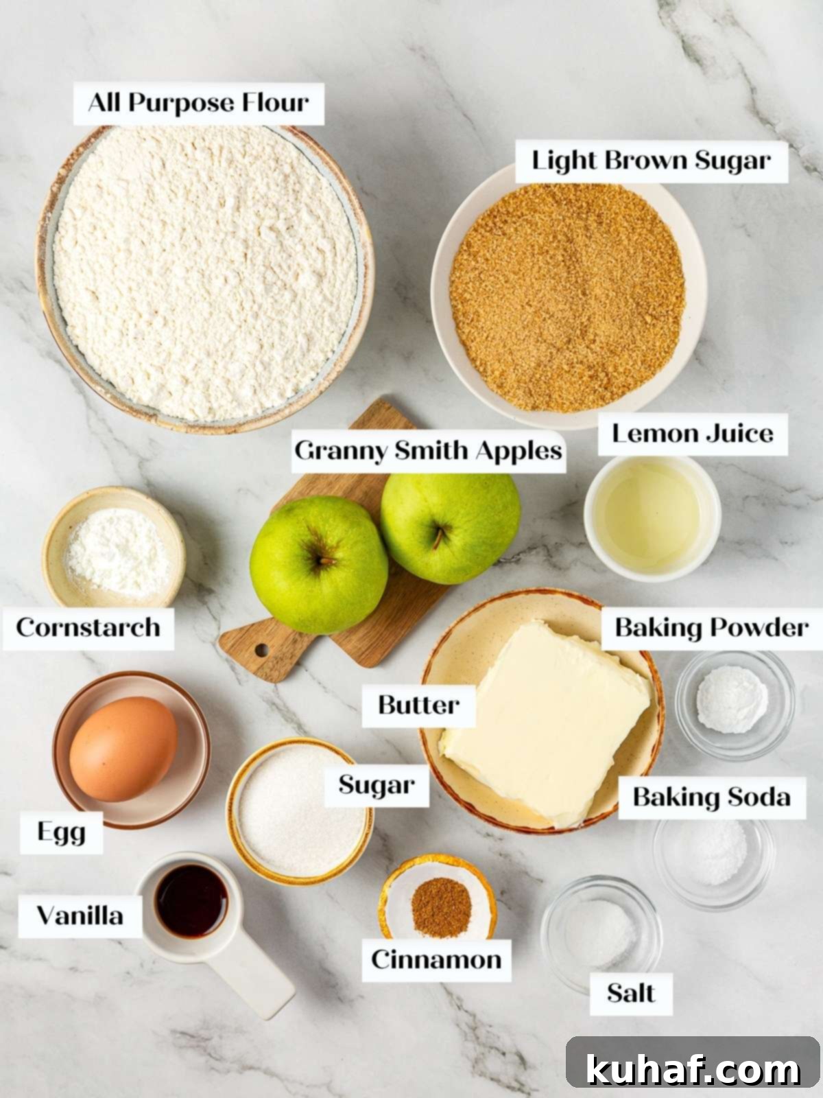 Arrangement of fresh Granny Smith apples, bags of flour and sugar, a stick of butter, and cinnamon sticks on a wooden kitchen counter, ready for baking apple pie cookies.