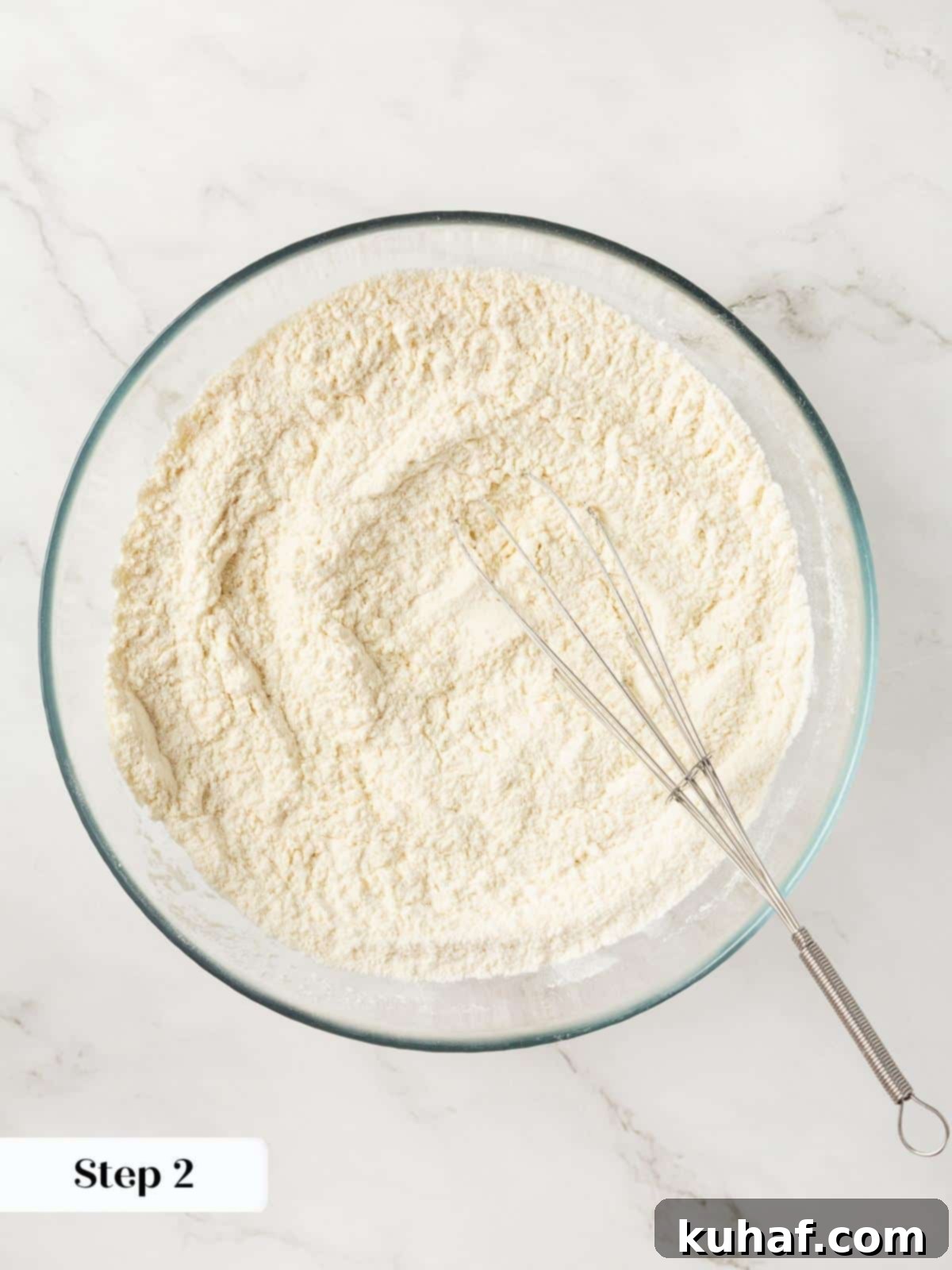 Dry ingredients for cranberry cookies being whisked together in a large mixing bowl.