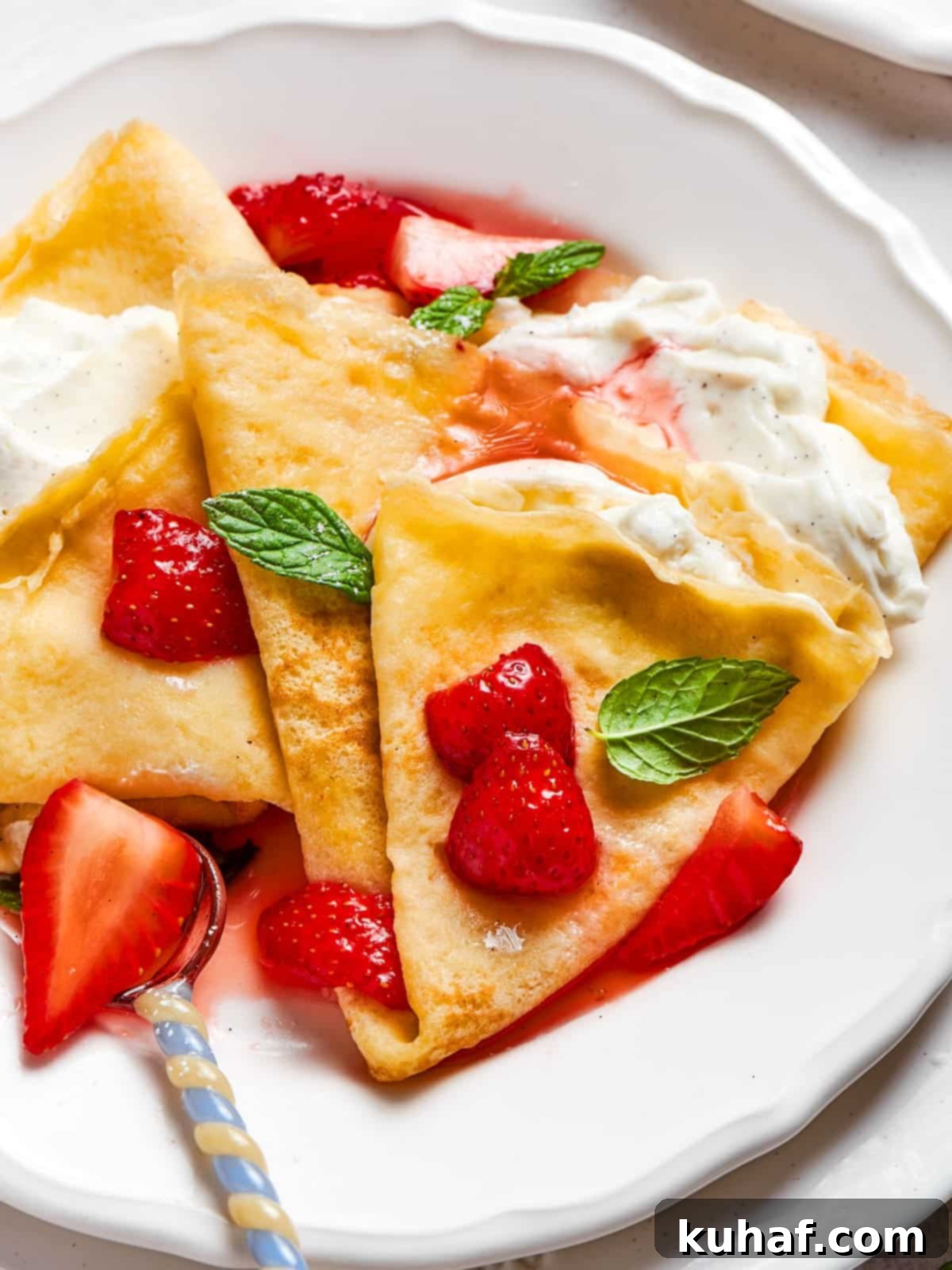 Bright red strawberry crepes folded neatly and served warm with a soft, tender texture.