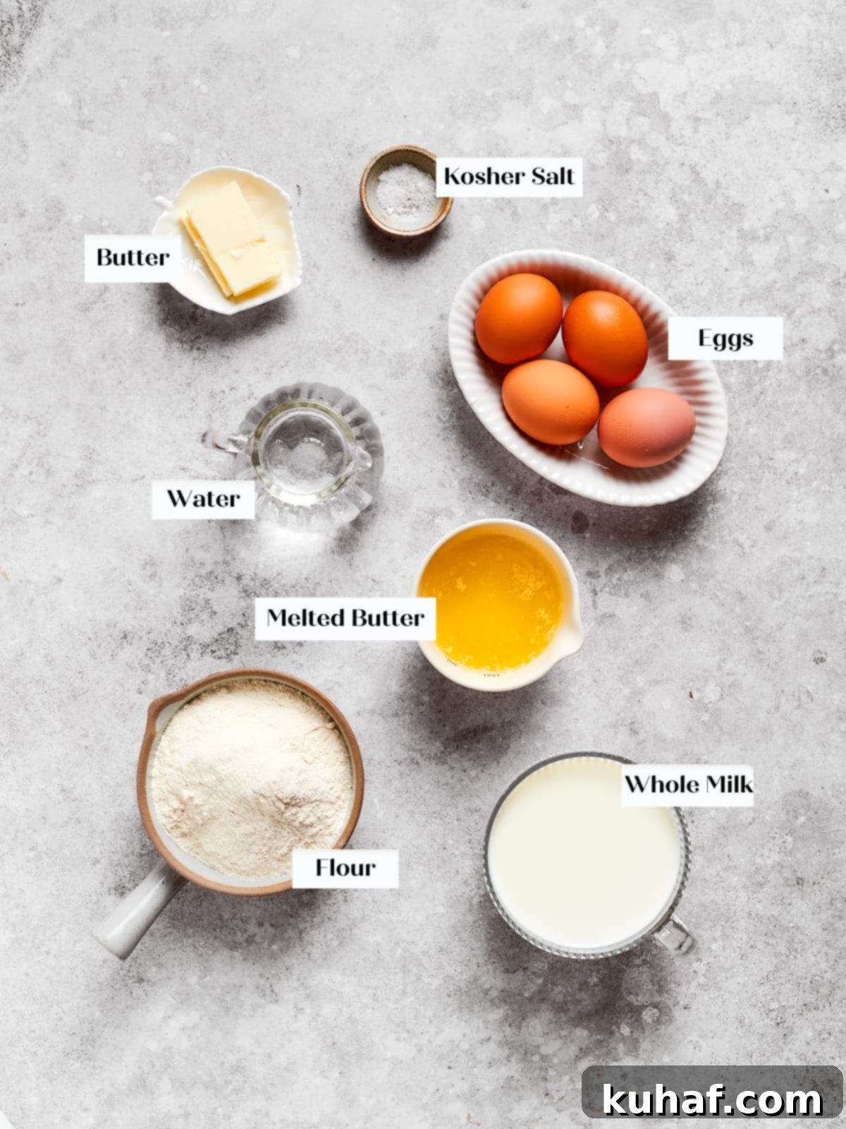 Eggs, flour, milk, and butter arranged on a countertop before mixing the crepe batter.