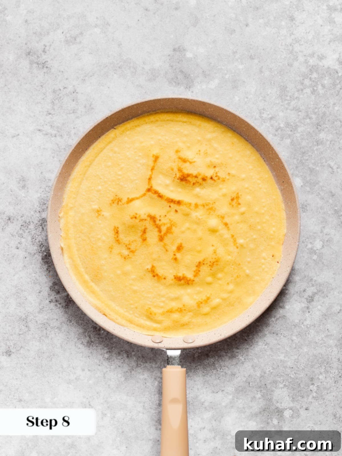 Freshly flipped crepe revealing a warm golden hue and delicate texture in the skillet.