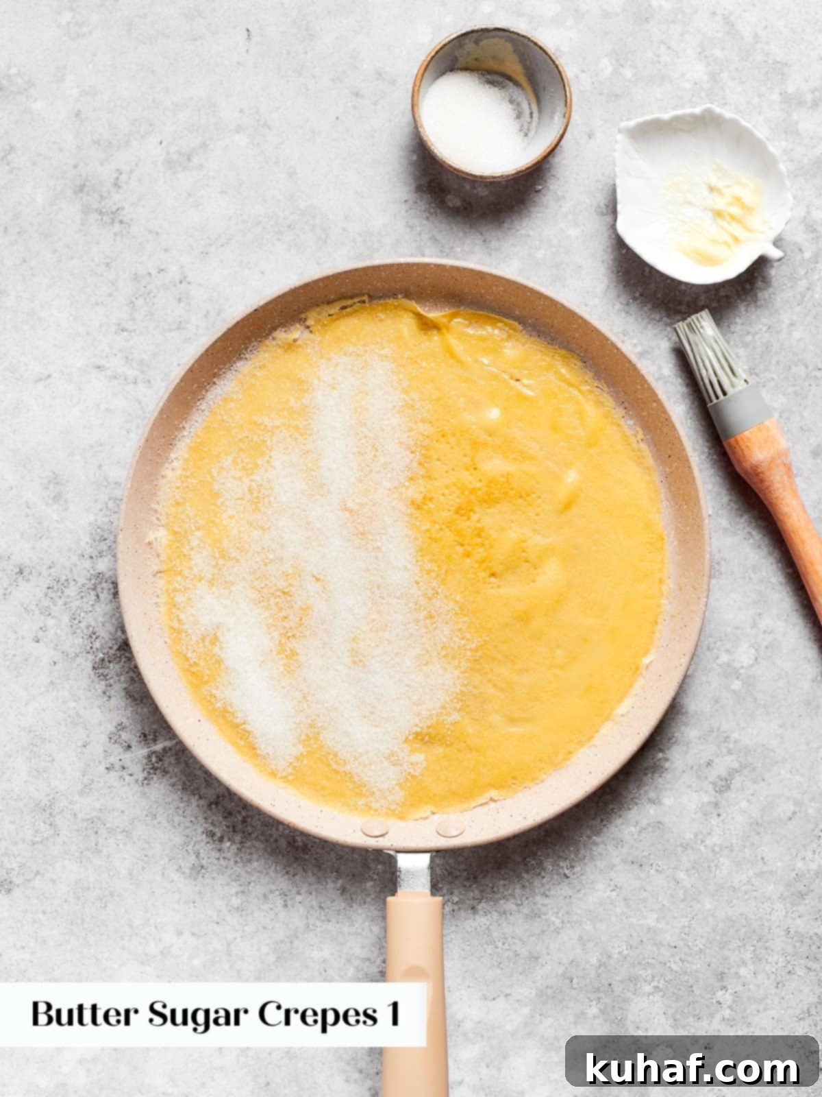 A warm crepe sprinkled on one side with sugar before folding in the pan.