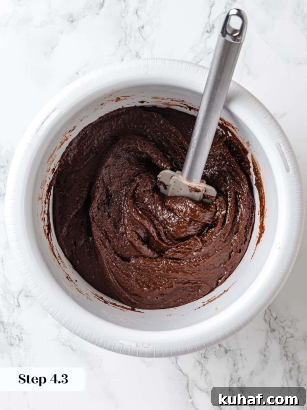 Gently folding the dry ingredients into the wet batter.