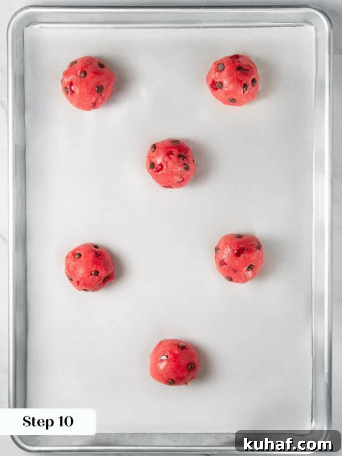 Cherry Chocolate Chunk Cookies 14 Rolled cherry cookie dough balls placed on parchment lined baking sheet.