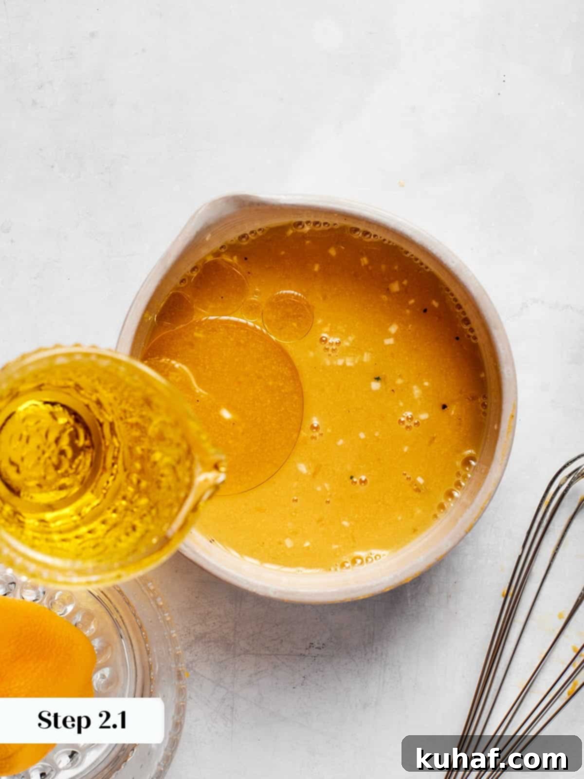 Champagne Vinaigrette Dressing 7 Slowly pouring olive oil into champagne vinaigrette while whisking