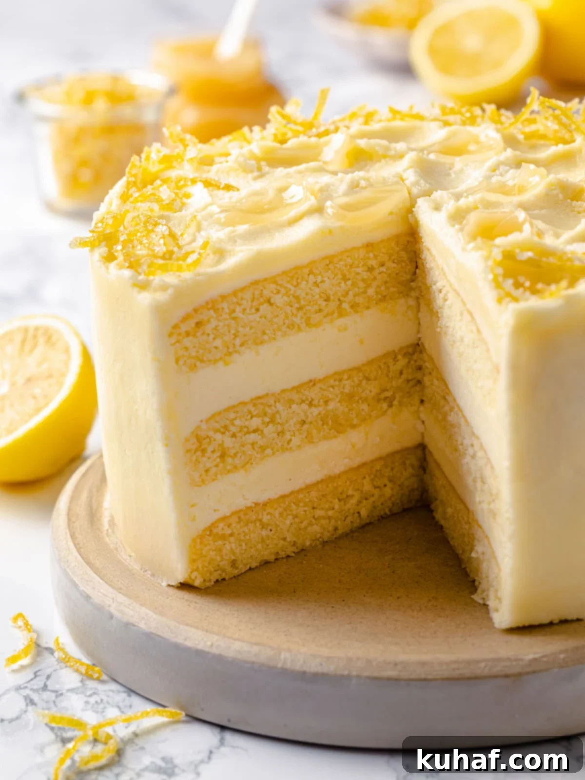 Cut lemon cake showcasing structured layers, smooth frosting, and moist crumb within.