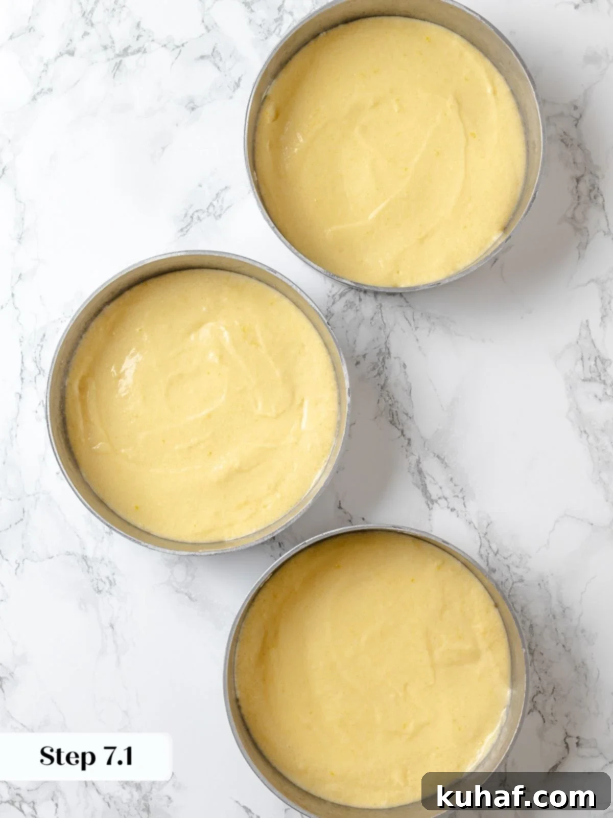Lemon cake batter evenly divided among three prepared round cake pans.