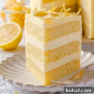 Lemon cake slice served on a scalloped plate with smooth buttercream and a soft crumb.