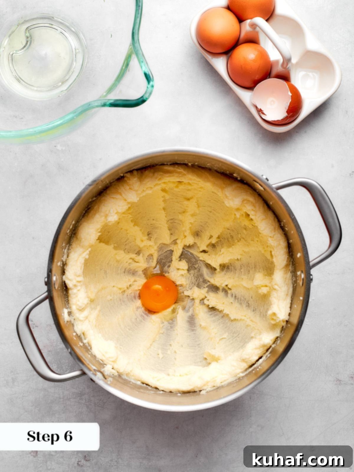 Egg yolk being added to the creamed butter and sugar mixture, enriching the cake batter.