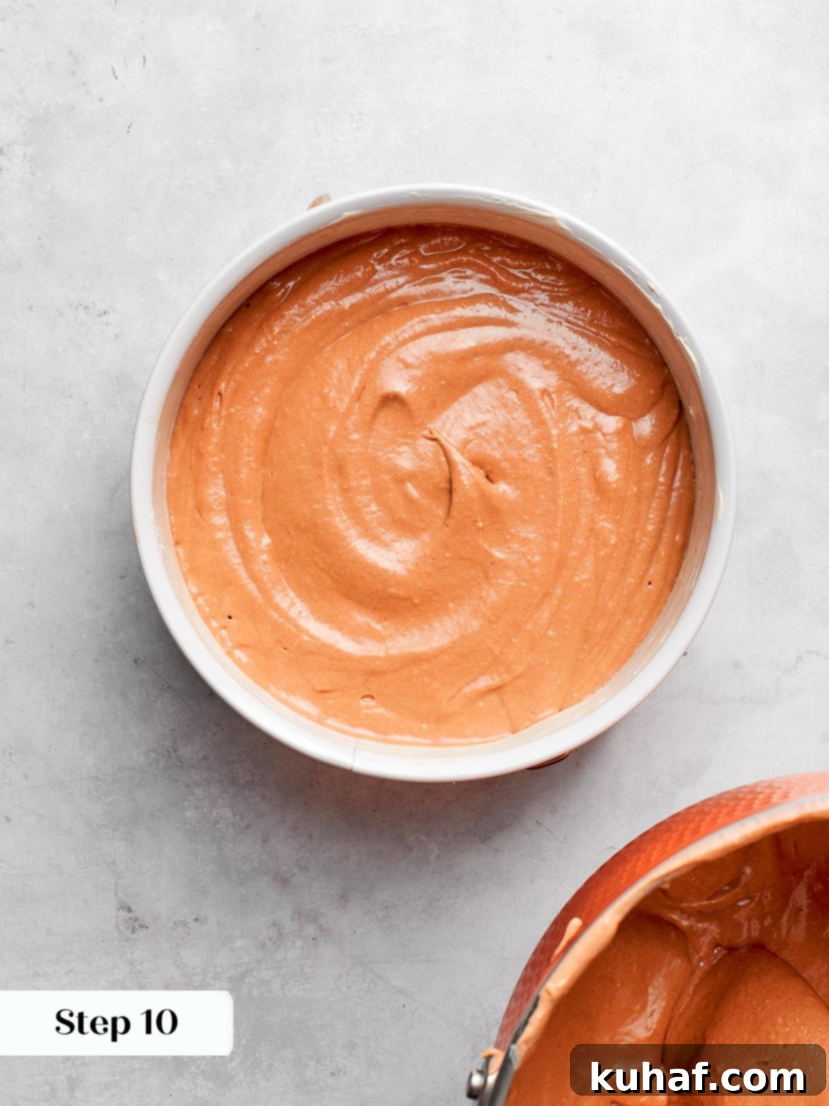 German chocolate cake batter being poured evenly into a prepared baking pan.
