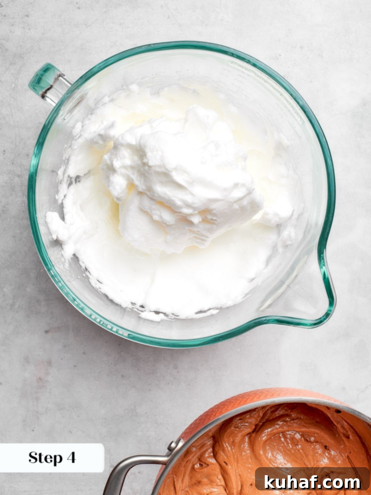 Egg whites whipped to stiff, glossy peaks in a mixer bowl, ready for the cake batter.