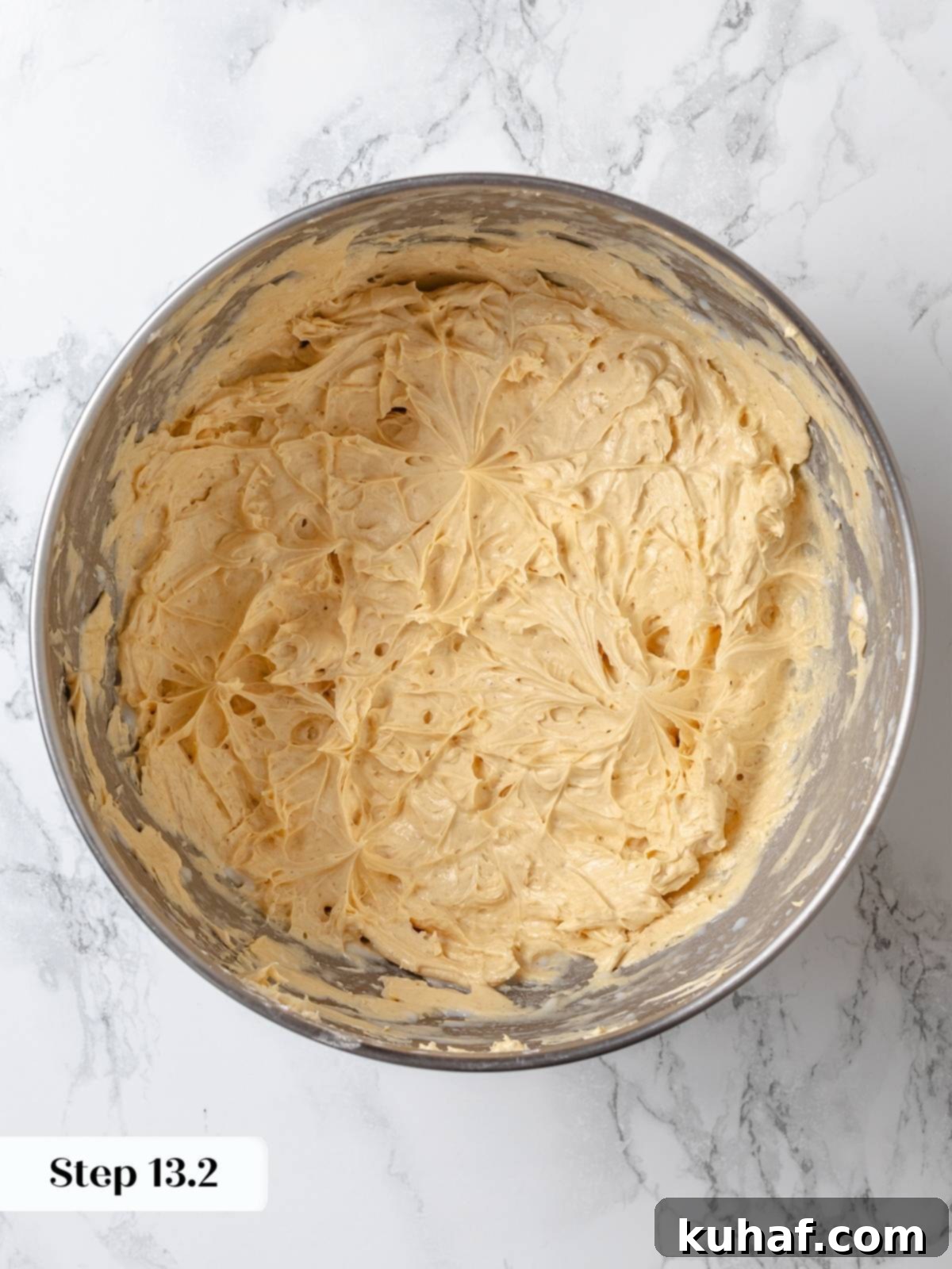 Peanut Butter Dream Cake 19 Peanut butter buttercream whipped smooth inside large silver mixing bowl.