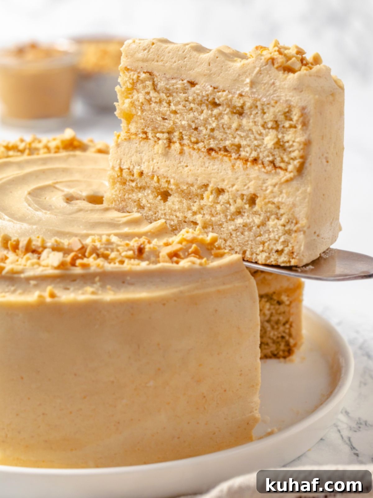 Peanut Butter Dream Cake 22 Cake server lifting slice of peanut butter layer cake.