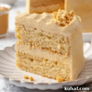 Slice of peanut butter cake showing tender crumb and creamy frosting layers.