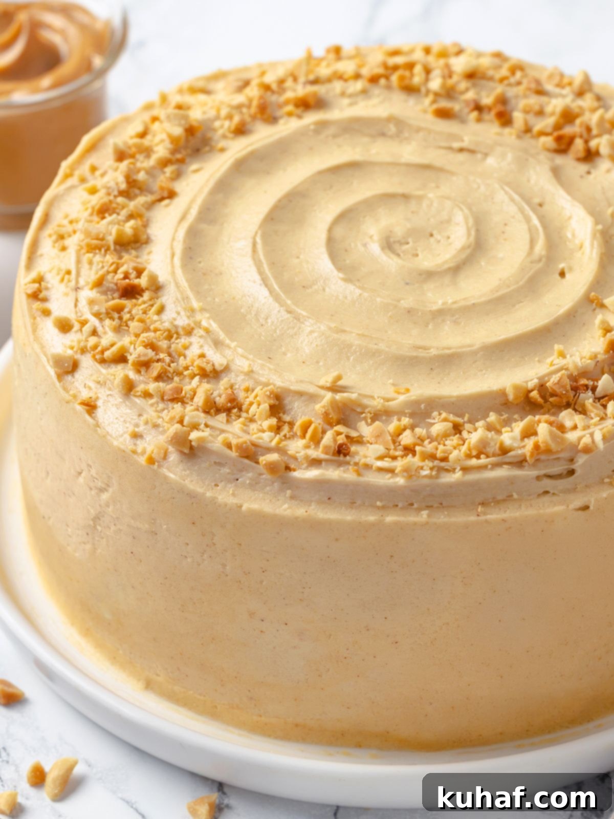 Layer cake generously frosted with smooth peanut butter buttercream and featuring impeccably polished sides.
