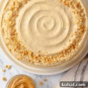Peanut butter buttercream cake beautifully garnished with chopped roasted peanuts for added crunch.