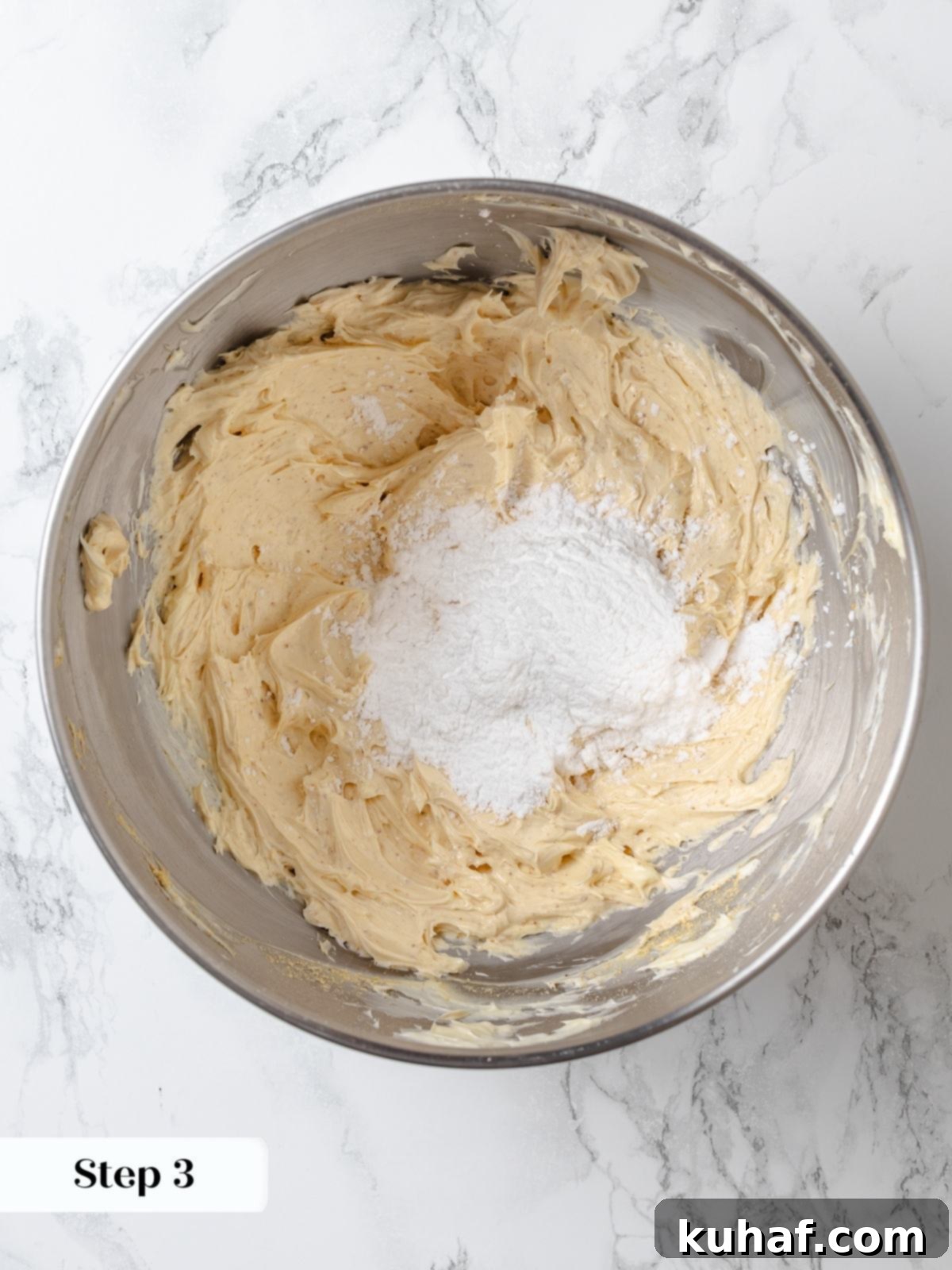 Powdered sugar gradually added to the butter mixture during the making of peanut butter buttercream.
