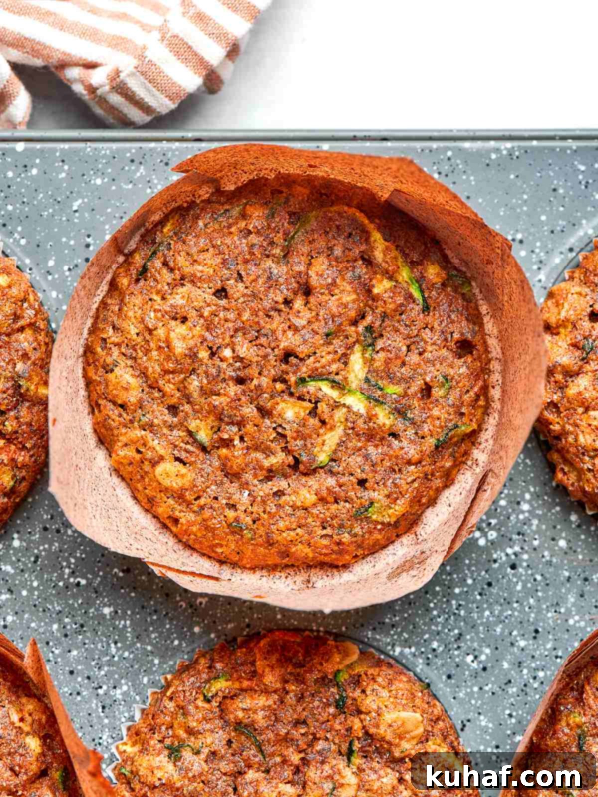 Fresh zucchini muffins with lightly set edges and golden tops.