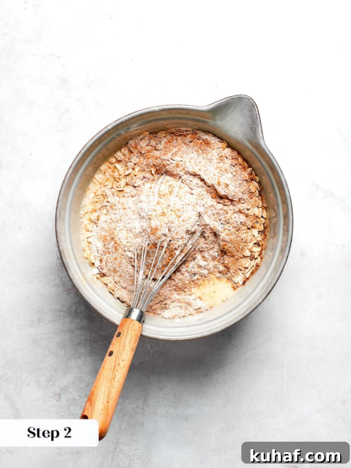 Dry ingredients whisked together including whole wheat flour oats flax and spices.